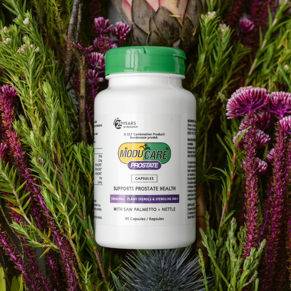 ModuCare Prostate supplement bottle with green lid on a natural background of plants and flowers