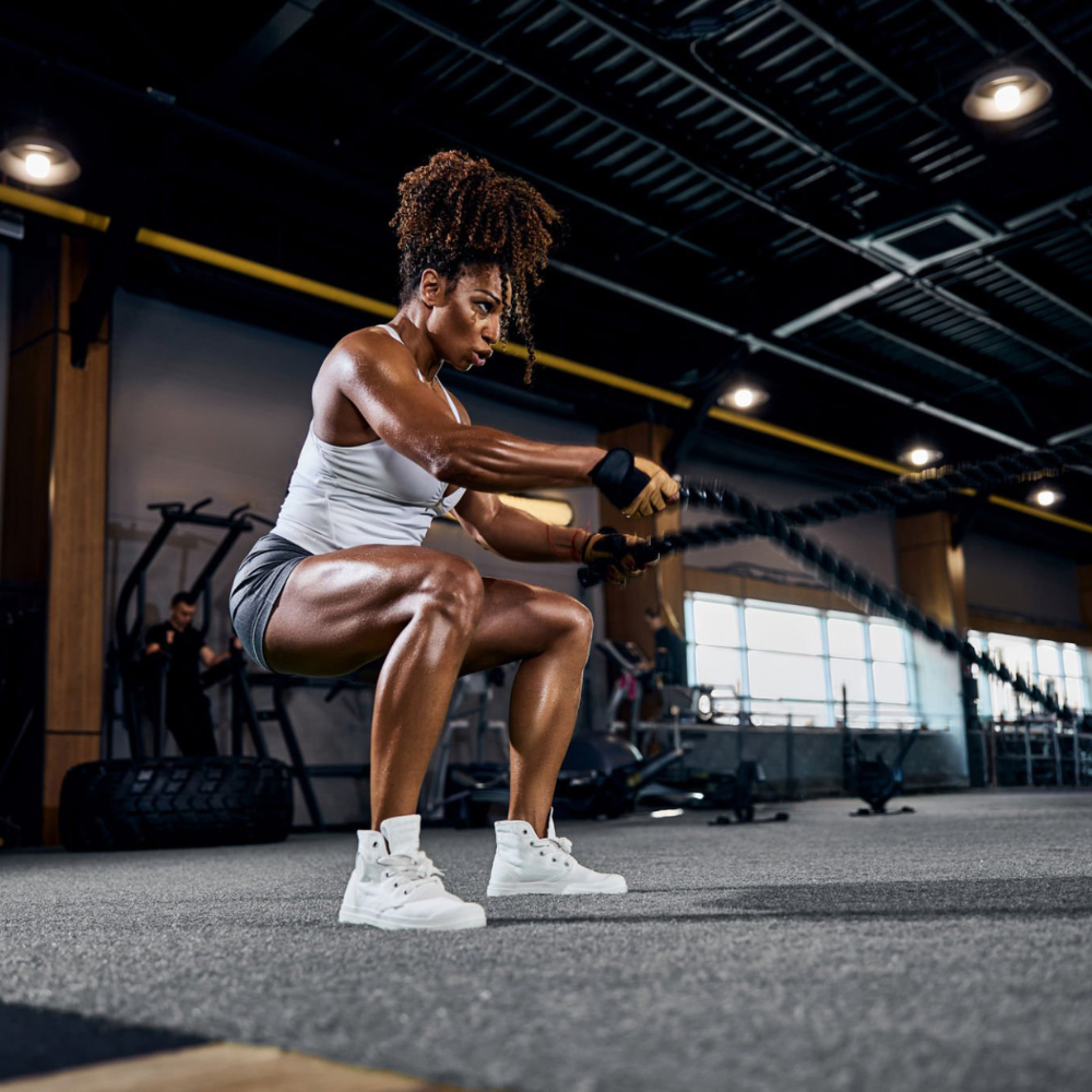 Woman performing a barbell squat in a gym setting