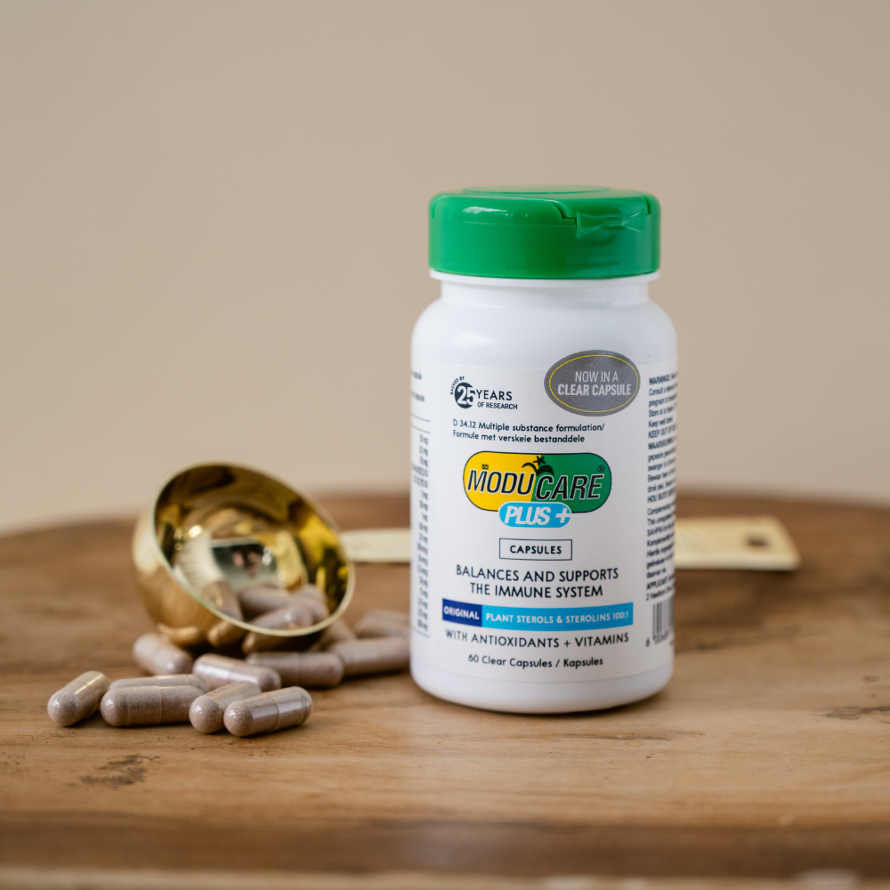 Moducare Plus+ supplement bottle with capsules on a wooden surface