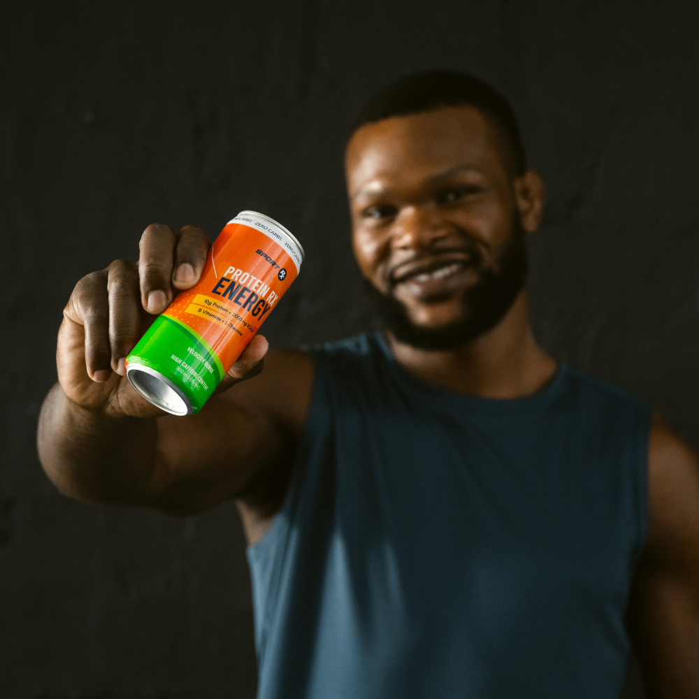 Man holding a can of Protein Energy drink against a dark background