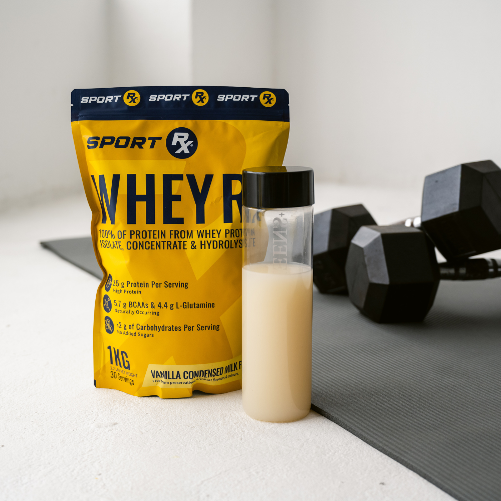 Sport Rx Whey protein package, protein shake, and dumbbells on a white surface with a gray background