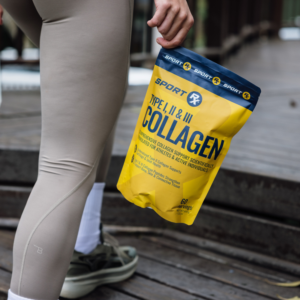 Person holding a package of Sport Collagen on a wooden surface