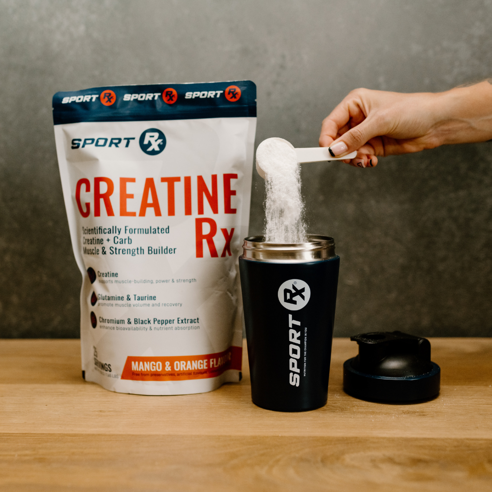 Person measuring creatine powder from a Sport RX Creatine Rx package into a black container on a wooden surface.
