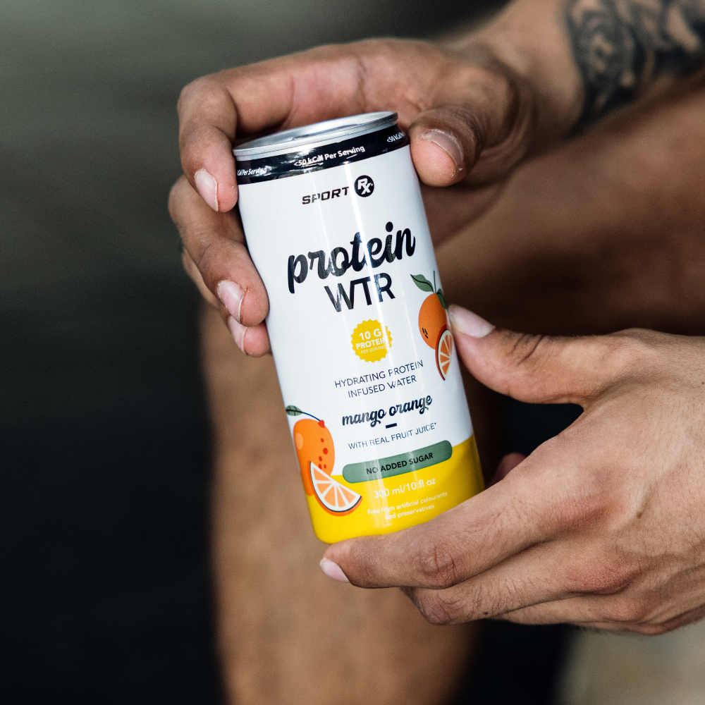 Person holding a can of Sport Rx Protein WTR Mango Orange flavor