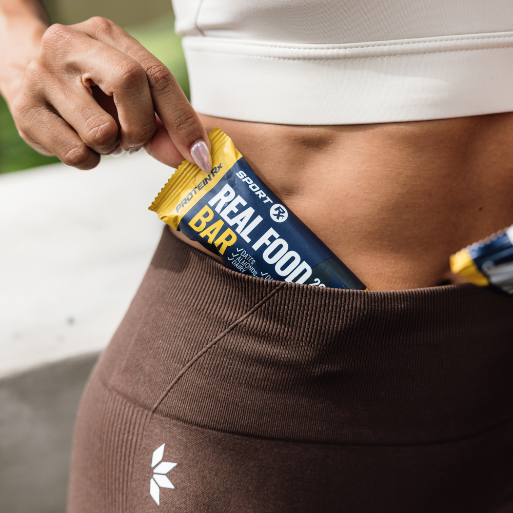 Person holding a Sport Rx protein bar package with a focus on fitness and nutrition.